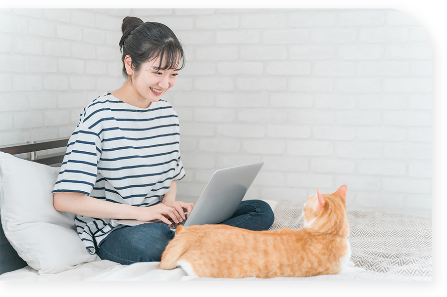 pcを持った女性が猫に笑いかけている写真