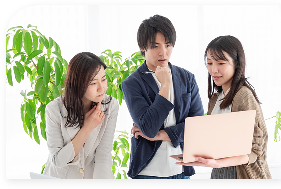 3人でpcを見ながら相談している写真